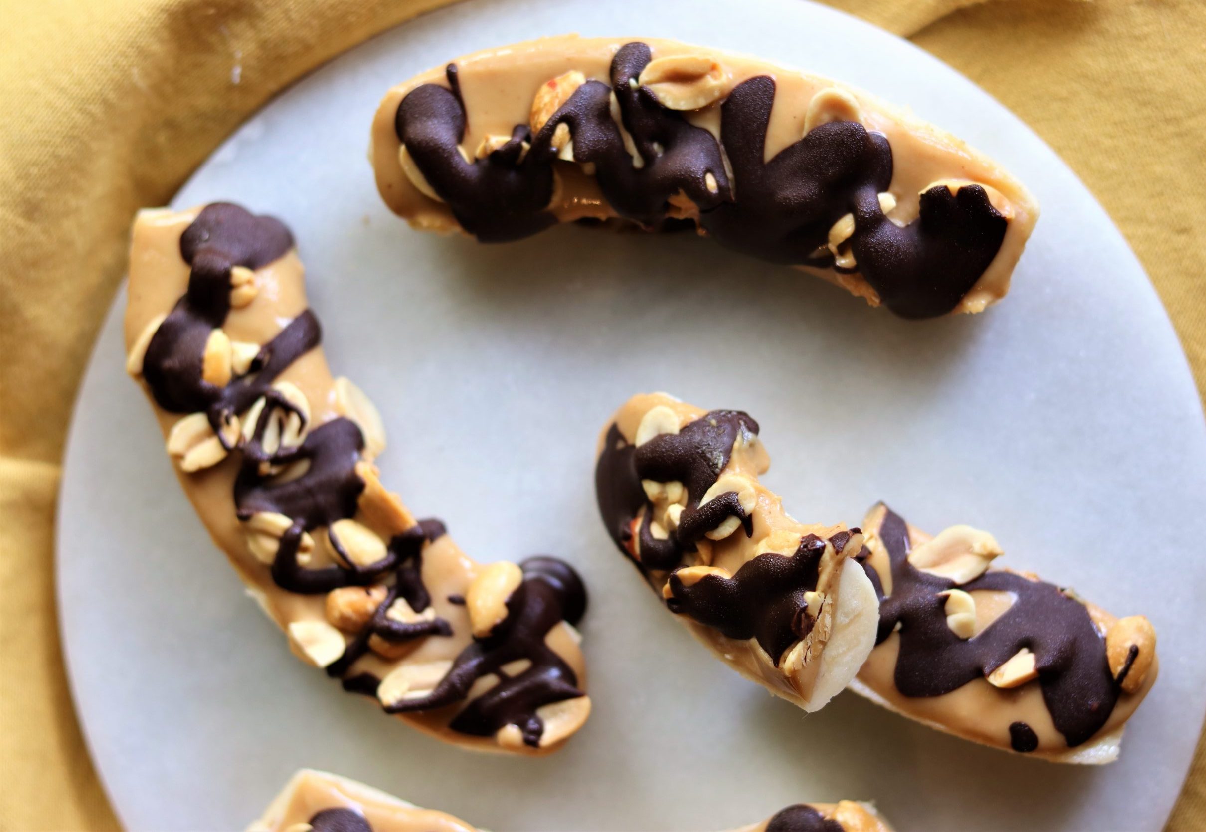 Banana congelada com cobertura de pasta de amendoim e chocolate 70%